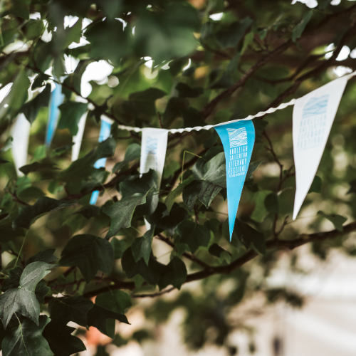 Budleigh Literary Festival bunting in between some trees